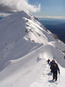 A group of people walking along a snow-covered mountain range